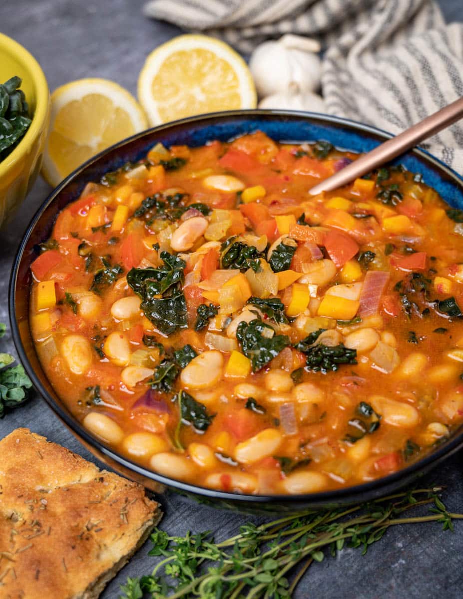 a bowl of harissa soup with lemons on the side