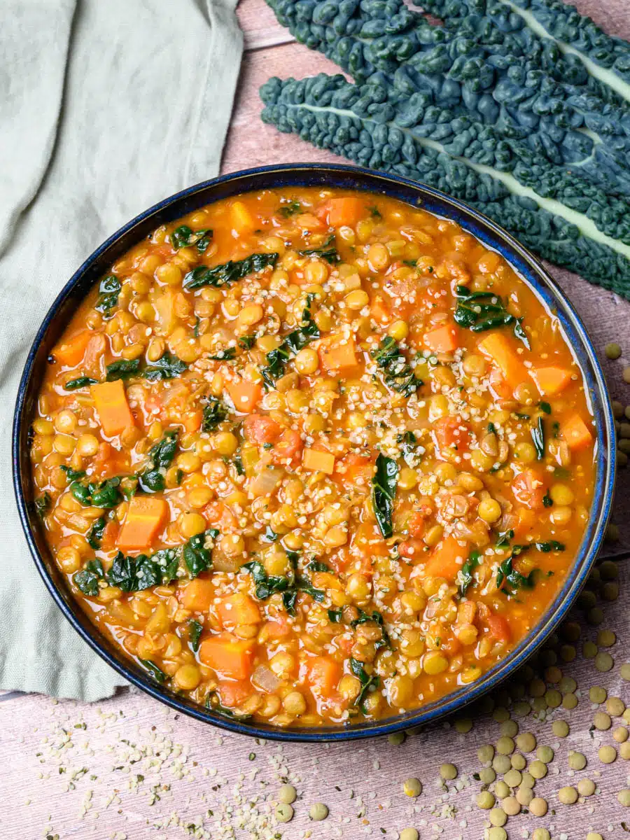 Protein-packed lentil soup with red lentils spiced tomato base spinach and lemon in a large bowl with bread